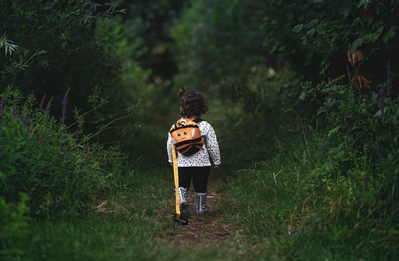 Child exploring nature with backpack